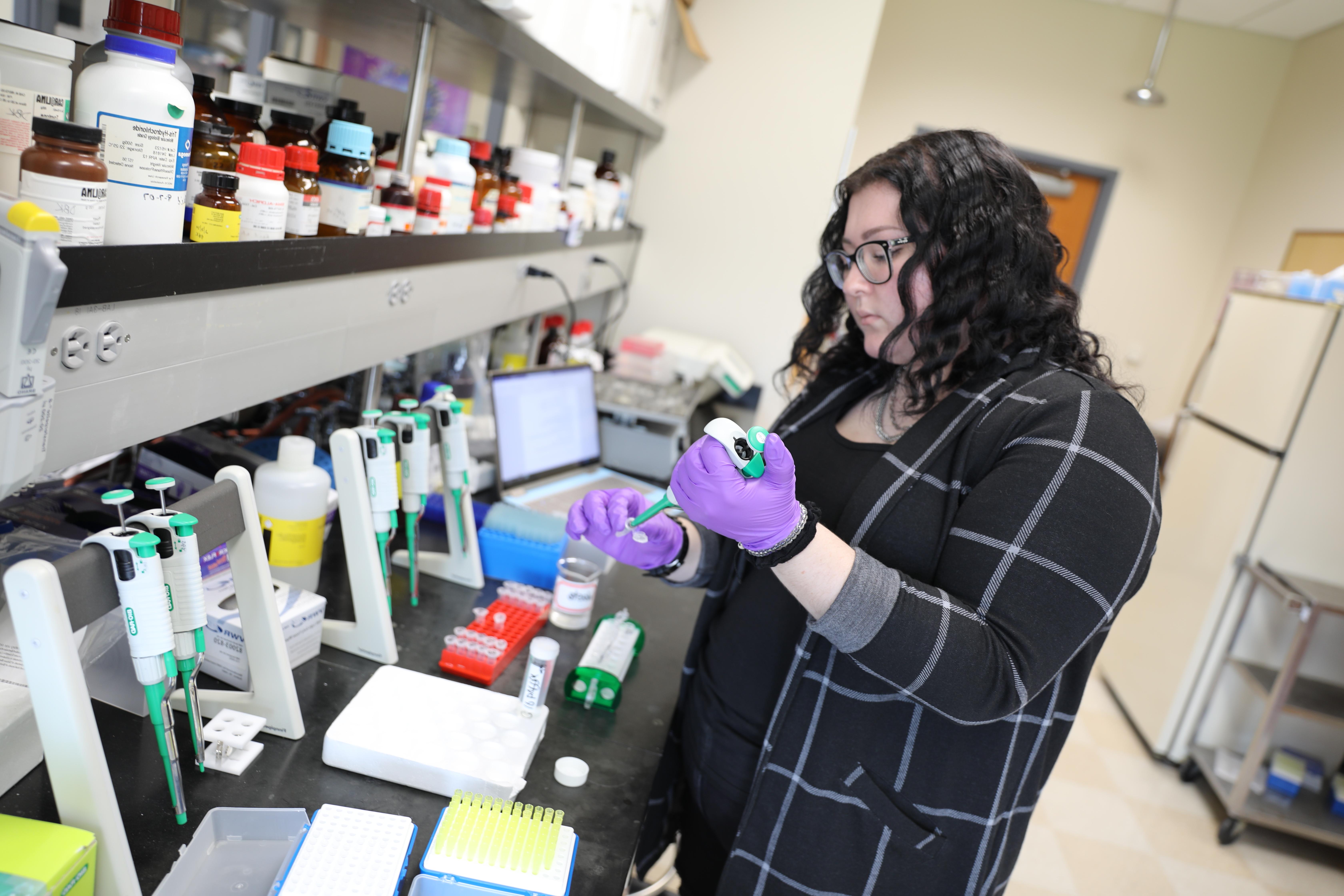 Biochemistry student in lab using chemicals