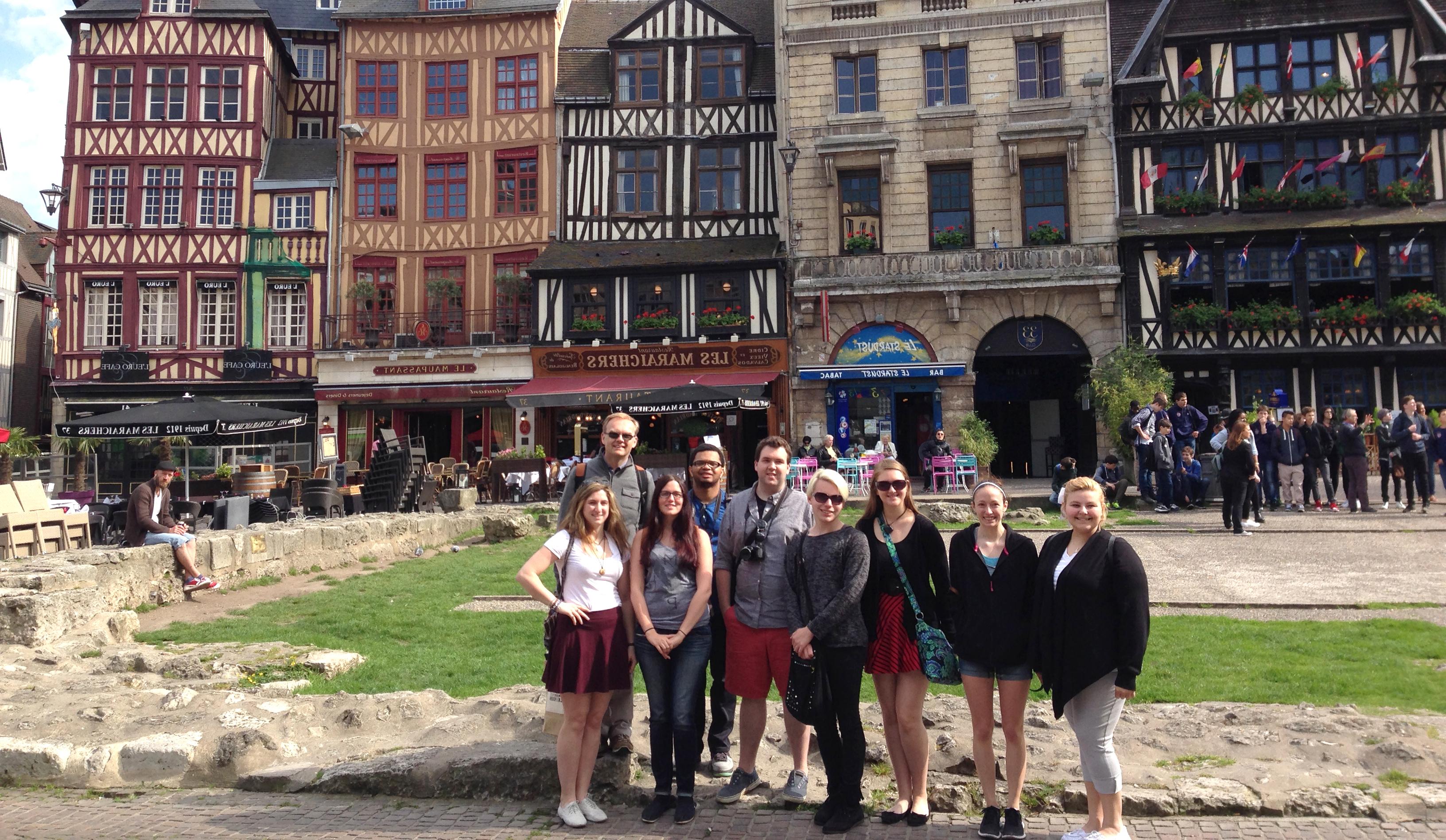 Professor with a group of students gathered in a French city